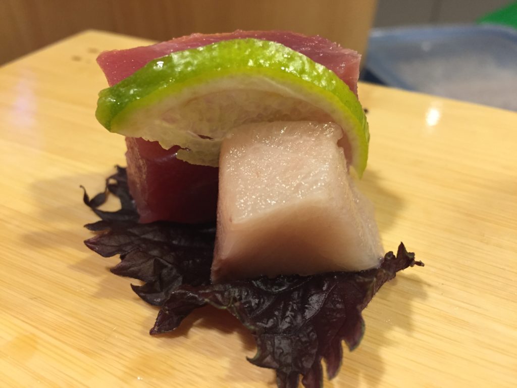 Sashimi di tonno e ricciola con yuzu su letto di shiso rosso
